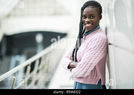 Young african woman with crossed hands standing in office hall Stock Photo