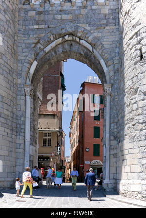 Pedestrians walking through the Towers of Porta Soprana, the best-known gate of the ancient walls of Genoa. After major restorations carried out betwe Stock Photo