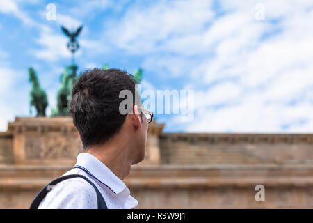 Young asian tourist or business man in Berlin (Germany) looking up to statue of Brandenburg Gate (copy space) Stock Photo