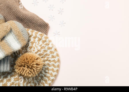 Warm knitted hat, gloves on pink background. Winter season concept Stock Photo
