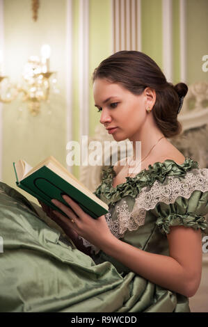 Portrait of retro baroque fashion woman wearing green vintage dress at old palace interior Stock Photo