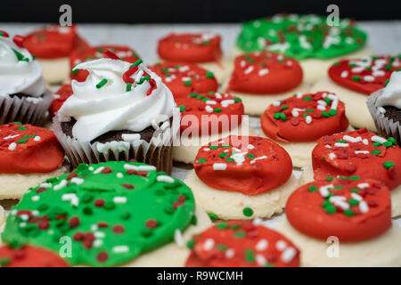 Yummy Christmas holiday baked goods in traditional red, green and white colors. Cupcakes and cookies Stock Photo
