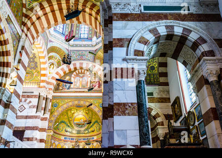 The richly mosaic decorated chancel of Notre-Dame de la Garde basilica in Marseille, France, with boat models hanging from the ceiling as ex-voto. Stock Photo