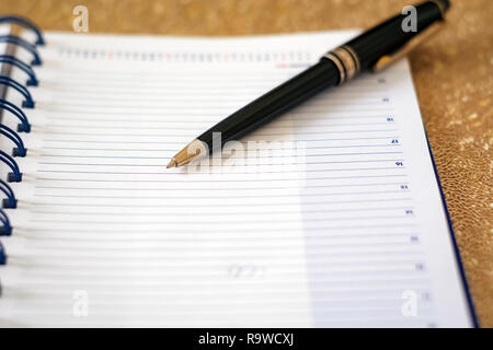 a black pen on an open notebook. Business and scheduling concept Stock Photo