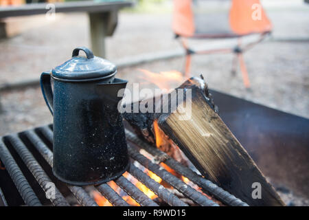 Tea Kettle sitting on an open grill campfire at a campground Stock Photo