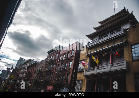 Typical New York City buildings in warm fall colours with external fire stairs in China Town, NYC Stock Photo