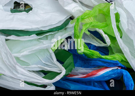 Multiple plastic shopping bags / carrier bags. For plastic bag tax, bag charge, war on plastic, plastic pollution UK, pile RM as identifiable colours. Stock Photo