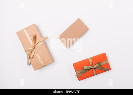 Three gifts on white table, view from above. Flat lay composition of preparation presents for holiday. Stock Photo