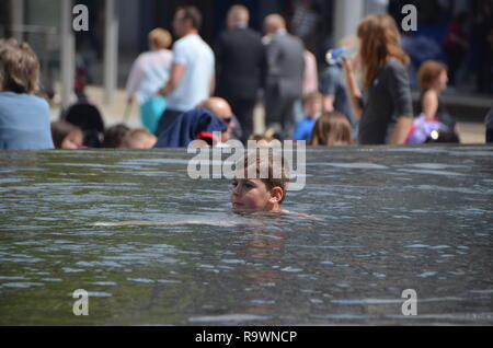 Boy swimming in a fountain pool Stock Photo
