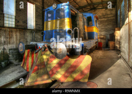Old abandoned diesel locomotive in a former factory Stock Photo