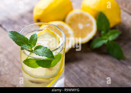 Lemon water with fresh lemons and green mint on table Stock Photo