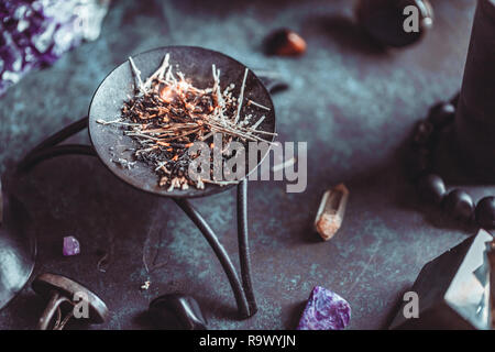 Burning herbs on a witch's altar for a magical ritual among crystals and  black candles Stock Photo - Alamy