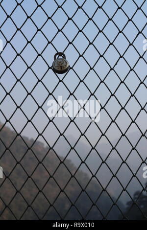 lock on a Metal Wire Mesh Barrier on a Bridge in Pauri Garhwal, Rishikesh, India Stock Photo