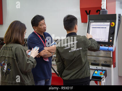 Bangkok, Thailand - November 23, 2018: Operator input data to operate metal sheet slotting machine in Metalex 2018 Stock Photo