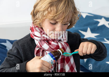 A little boy takes medicine, he has a cold, cough syrup, Stock Photo