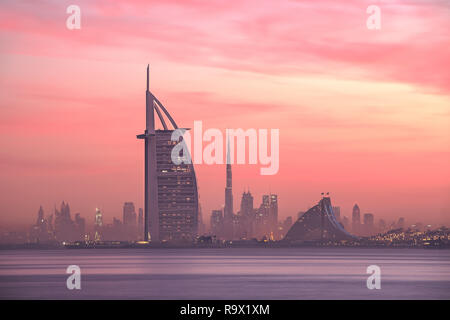 Stunning view of Dubai skyline from Jumeirah beach to Downtown lighted with warm pastel sunrise colors. Dubai, UAE. Stock Photo