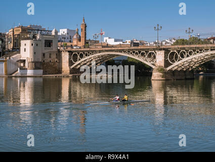 Isabel II bridge, better known as Puente de Triana bridge, as it crosses the Guadalquivir river, Triana District, Seville, Spain Stock Photo