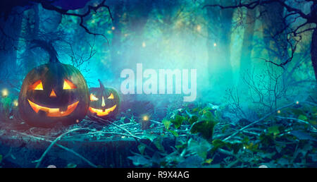 Halloween theme with pumpkins and dark forest. Scary Halloween design on table Stock Photo