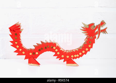 Diy chinese dragon on wall background. Gift ideas, decor Chinese new year. Handmade red gold lunar dragon lion from modular origami. Step by step. The Stock Photo