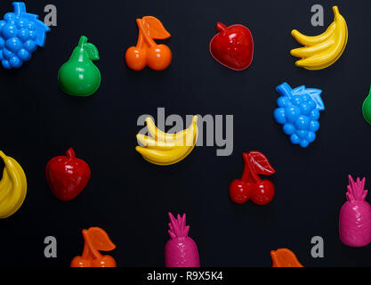 multicolored plastic toys fruits on a black background, close up Stock Photo