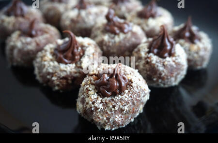 Chocolate delicious homemade praline decorated with grated hazelnut on the black plate Stock Photo