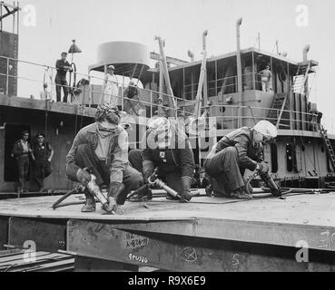Chippers in a Shipyard Shipbuilding. Three Women Working, 1942 Stock Photo