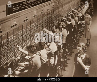A Bell System switchboard where overseas calls are handled. Not all of the services shown are available during wartime conditions. December 22,1943 Stock Photo