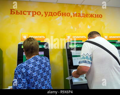 Voronezh, Russia - July 14, 2018: People pay utility bills using express service terminals. Stock Photo