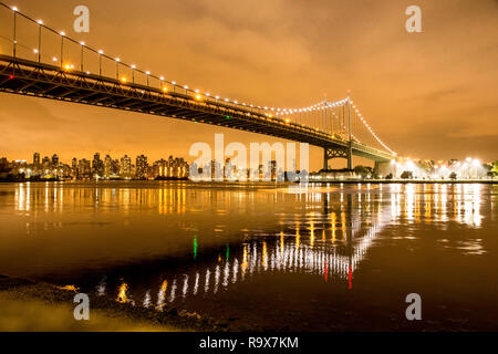 View of RFK Triborough Bridge from Astoria Queens towards Roosevelt Island and Manhattan New York City seen at night Stock Photo