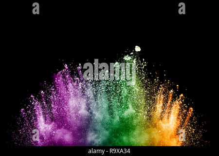 Multi color particles explosion on black background. Colorful dust splatter on dark background. Stock Photo