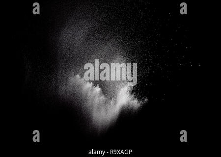 Freeze motion of white particles on black background. Powder explosion. Abstract dust overlay texture. Stock Photo