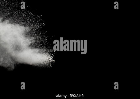White powder explosion on black background.Stopping the movement of white powder on dark background. Launched white powder splash. Stock Photo