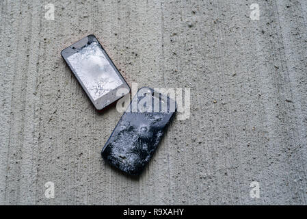 Phones with broken screen on concrete backgroung Stock Photo