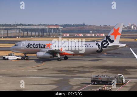 TOKYO, JAPAN - DECEMBER 5, 2016: Jetstar Japan Airbus A320 is towed at Narita Airport of Tokyo. The airport is the 2nd busiest airport of Japan (after Stock Photo
