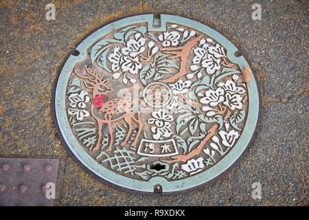 NARA, JAPAN - NOVEMBER 23, 2016: Manhole cover in Nara. Japan frequently has beautiful decorative sewer covers. Stock Photo