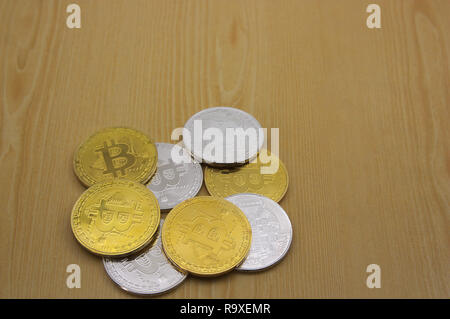 An image of a bunch of gold and silver coins of bitcoins on a wooden table with space to place texts (copy space) Stock Photo