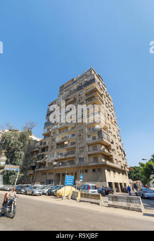 Street scene in Giza, Cairo, Egypt with typical large roadside residential apartment block with satellite dishes and external air-conditioning units Stock Photo