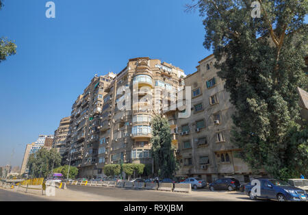 Street scene in Giza, Cairo, Egypt with typical large roadside residential apartment block with satellite dishes and external air-conditioning units Stock Photo