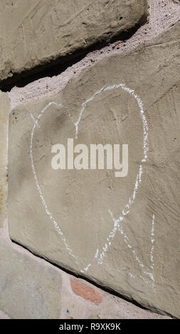 Heart drawn in white chalk on a sandstone brick wall Stock Photo