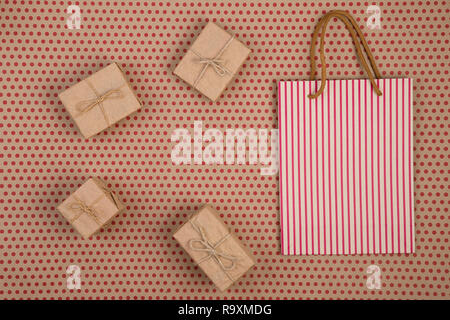 Celebratory concept - gift  boxes and decorative handmade collection of craft paper with rope and striped shopping bag, gift bags on craft  paper back Stock Photo