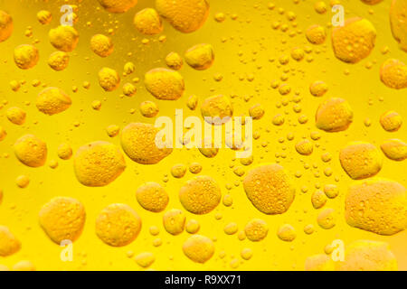 Abstract - Oil mixed in water on a yellow and lime colored background. Photographed in close up with shallow DOF. Photo taken:  November 12, 2018 Stock Photo