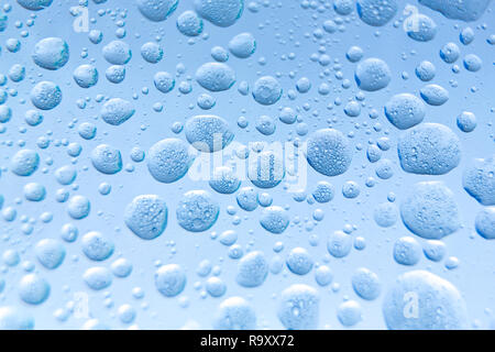 Oil mixed in water on a grey and blue background. Photographed in close up with shallow DOF. Photo taken:  November 12, 2018 Stock Photo