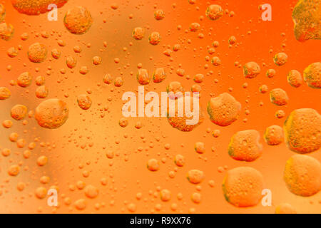 Oil mixed in water on a colorful yellow orange and golden background. Photographed in close up with shallow DOF. Photo taken:  November 12, 2018 Stock Photo