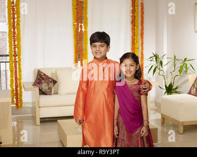 PORTRAIT OF INDIAN GIRL AND HER BROTHER DRESSED IN FORMAL CLOTHES ON A FESTIVE DAY Stock Photo
