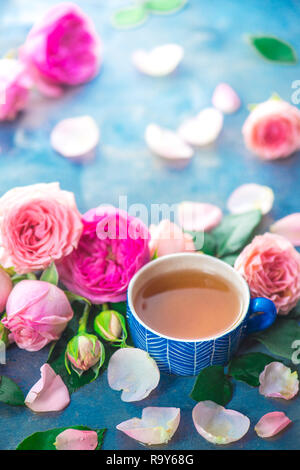 Rose tea in ceramic tea cups and flower petals on a wet light background with copy space. Seasonal drink photography Stock Photo