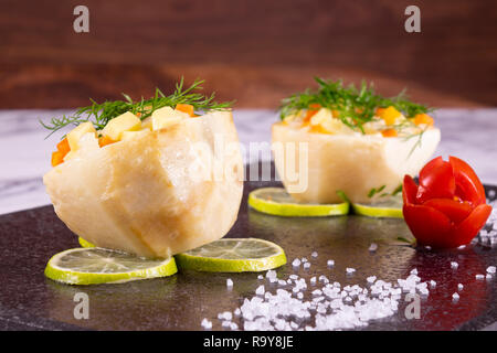 Artichoke food meal staffed with carrot and potatoes. This arthichoke dish on black marble plate. Delicious yummy tasty vegetarian veggie food Stock Photo