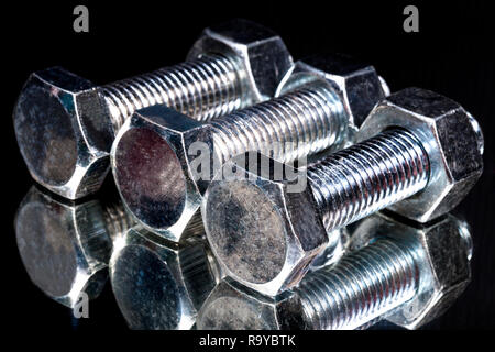 metal fasteners screws and nuts on black background. screw isolated on the black backgrounds. Nuts with bolts closeup Stock Photo