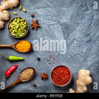 Ginger, chili peppers, cardamom, powder spices in spoons on grunge background Stock Photo