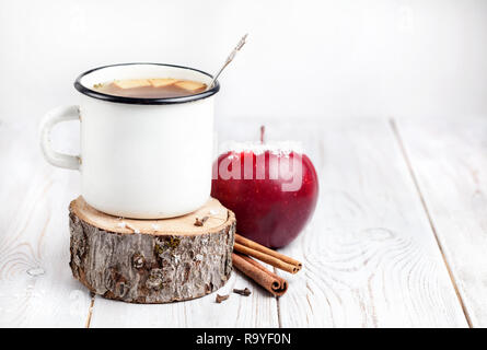 Hot beverage from apples and spices on white wooden background at Christmas time Stock Photo