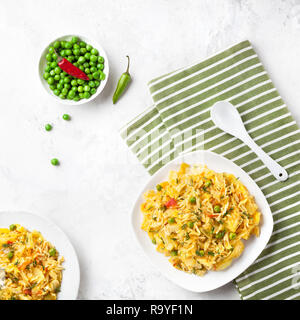 Indian Sabji with rice, vegetables, chili and peas on white table in restaurant Stock Photo